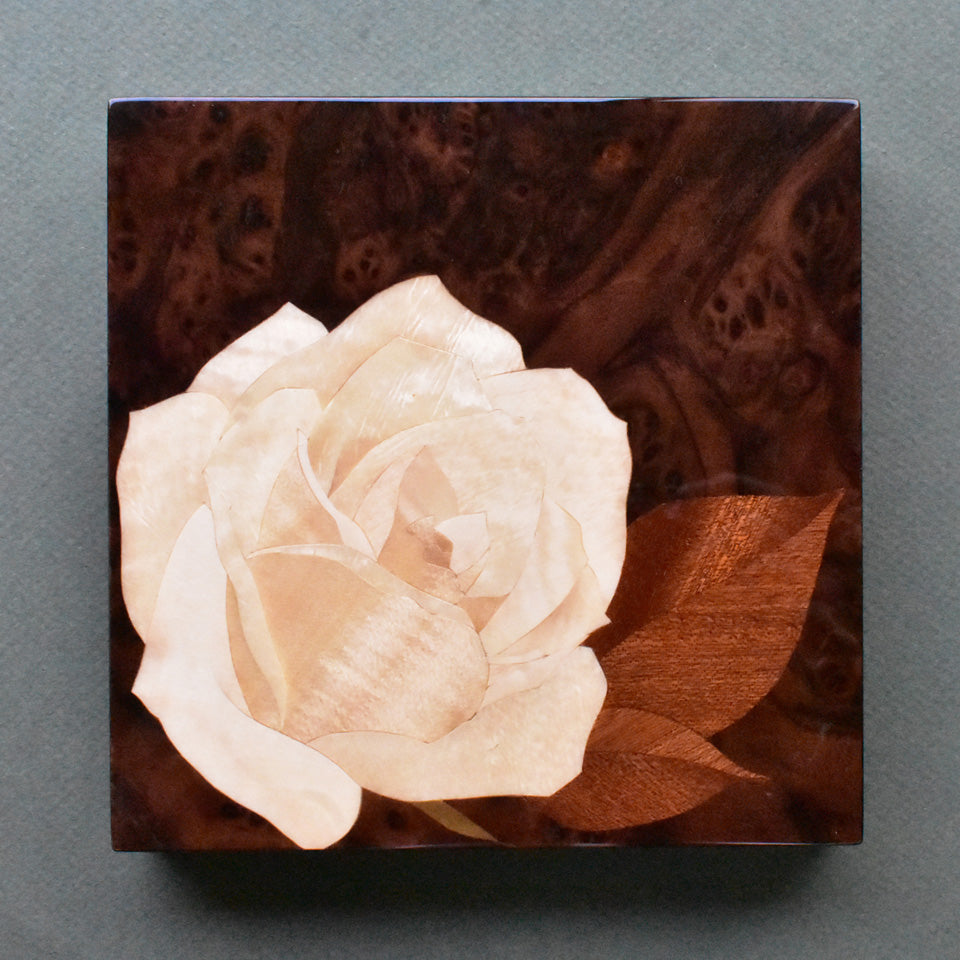 木象嵌パネル「白バラ」天然木を使って描いていますので光を受けて美しく輝きます。
The marquetry panel "White Rose" is created using natural wood, which shines beautifully when it catches the light.